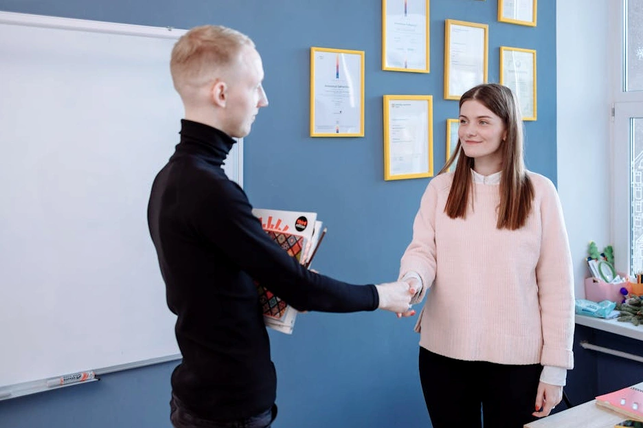 Un consulente sorridente che stringe la mano a un cliente in un ufficio moderno